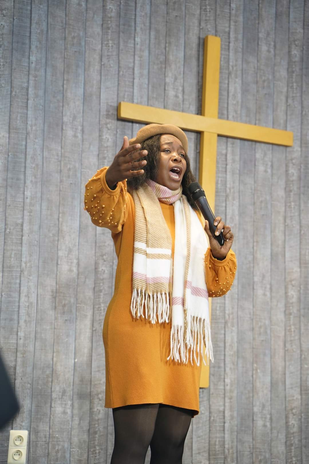 Angela Volcimus Louis en performance gospel, robe jaune et micro
